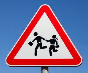A sign showing two children running.