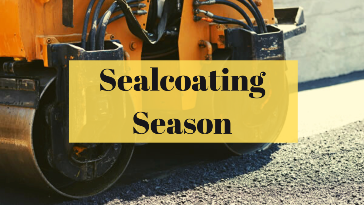 An image of a road roller compacting sealcoating with the text: Sealcoating Season.
