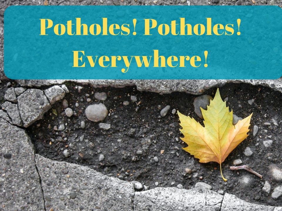 A photograph of a pothole with a leaf in it and the text: Potholes! Potholes! Everywhere!