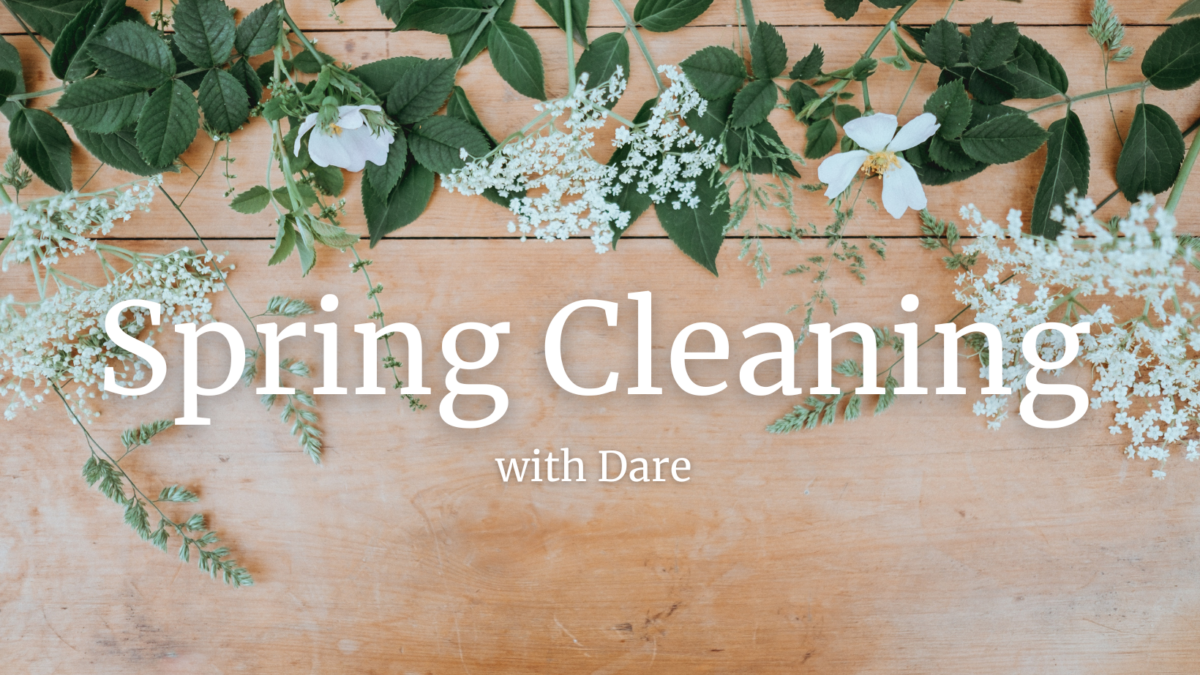 A photograph of flowers and leaves arranged on a table with the text: Spring Cleaning with Dare.