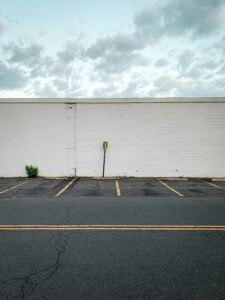 A photo of an empty parking lot in the summer.