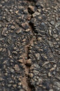 A photo of a crack in some asphalt.